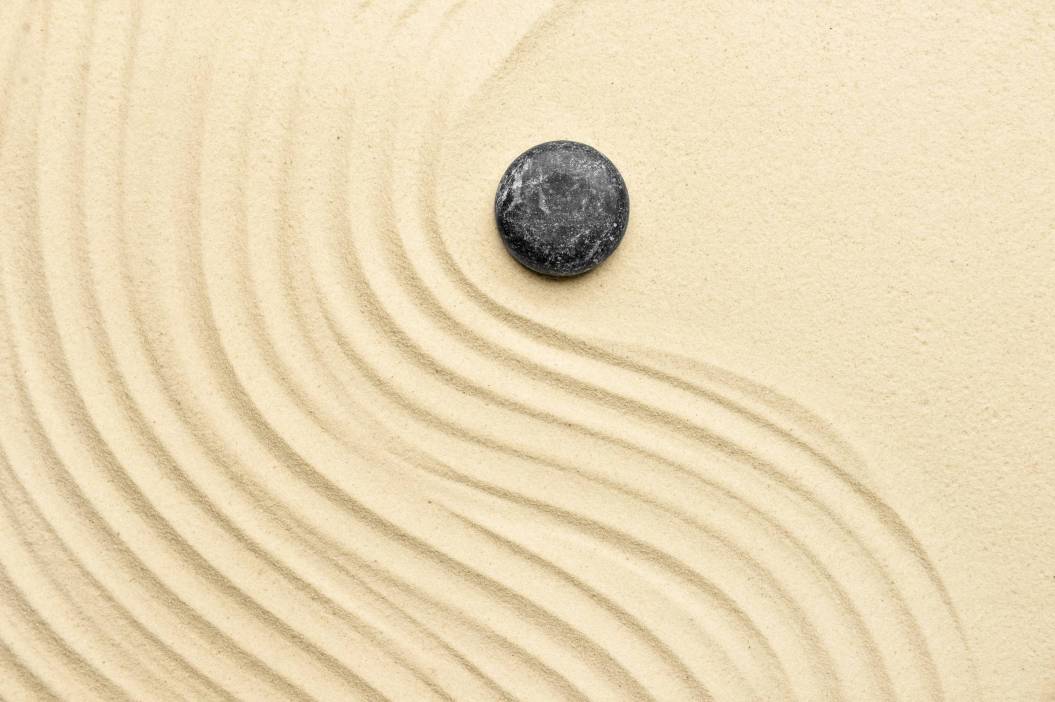 Black spa stone on light sand